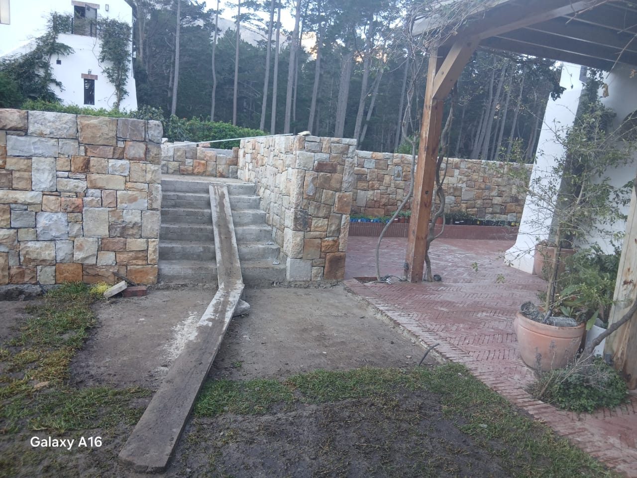 Stone terrace with steps and pergola in a landscaped Cape Town garden