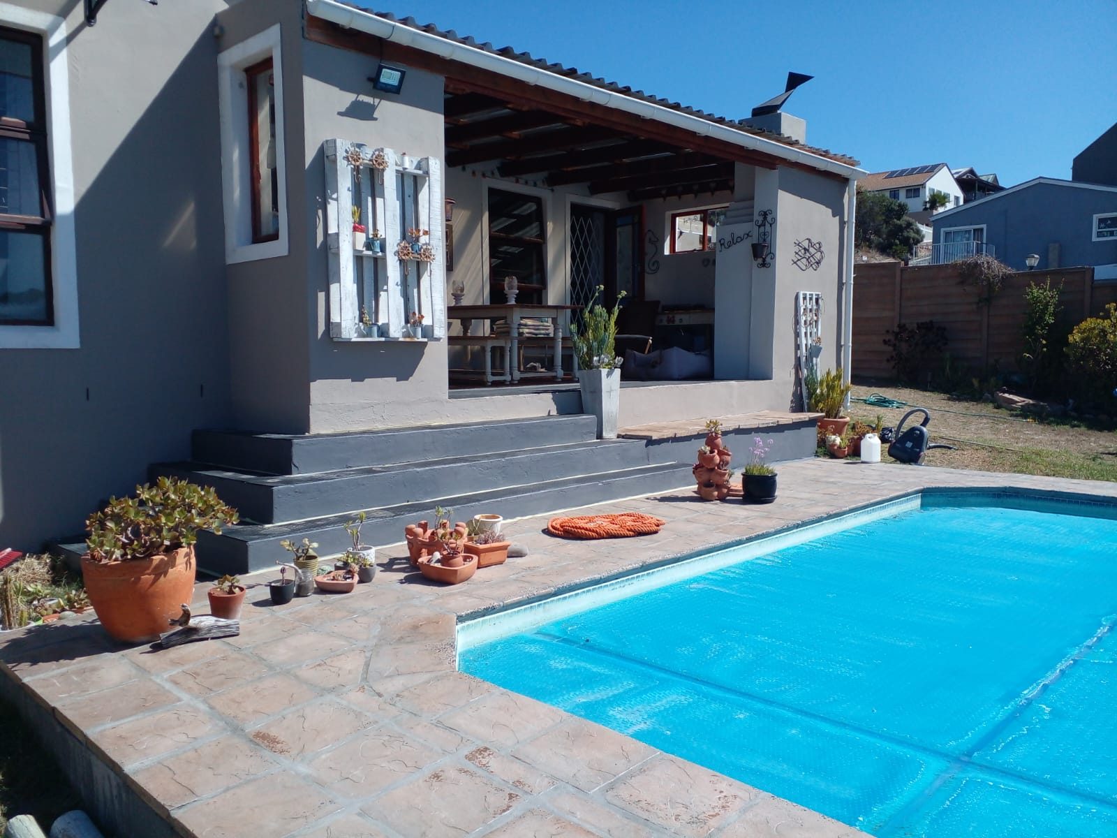 Renovated swimming pool with paved patio and freshly painted house in Cape Town