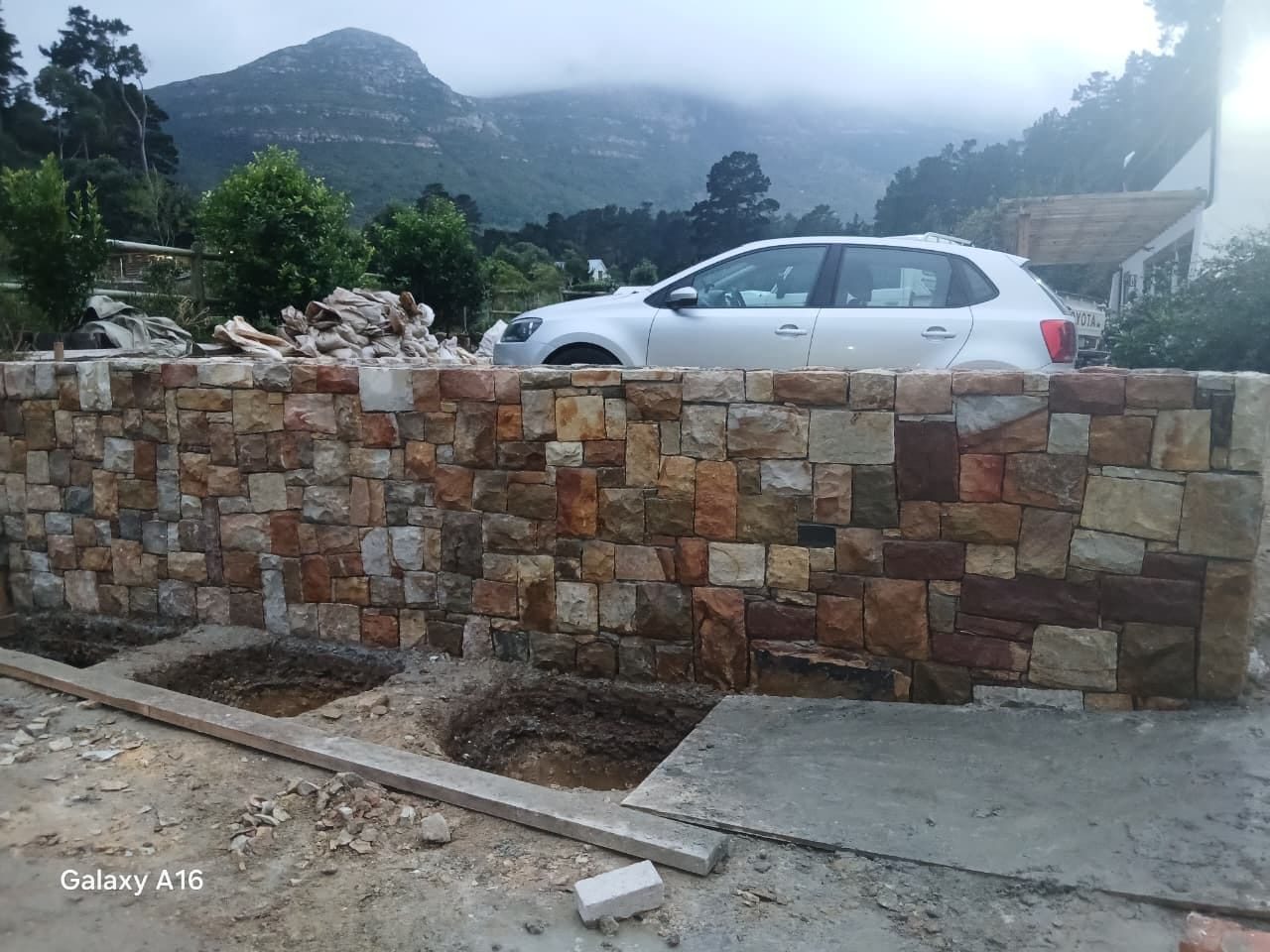 Stone-clad driveway boundary wall under construction in Cape Town
