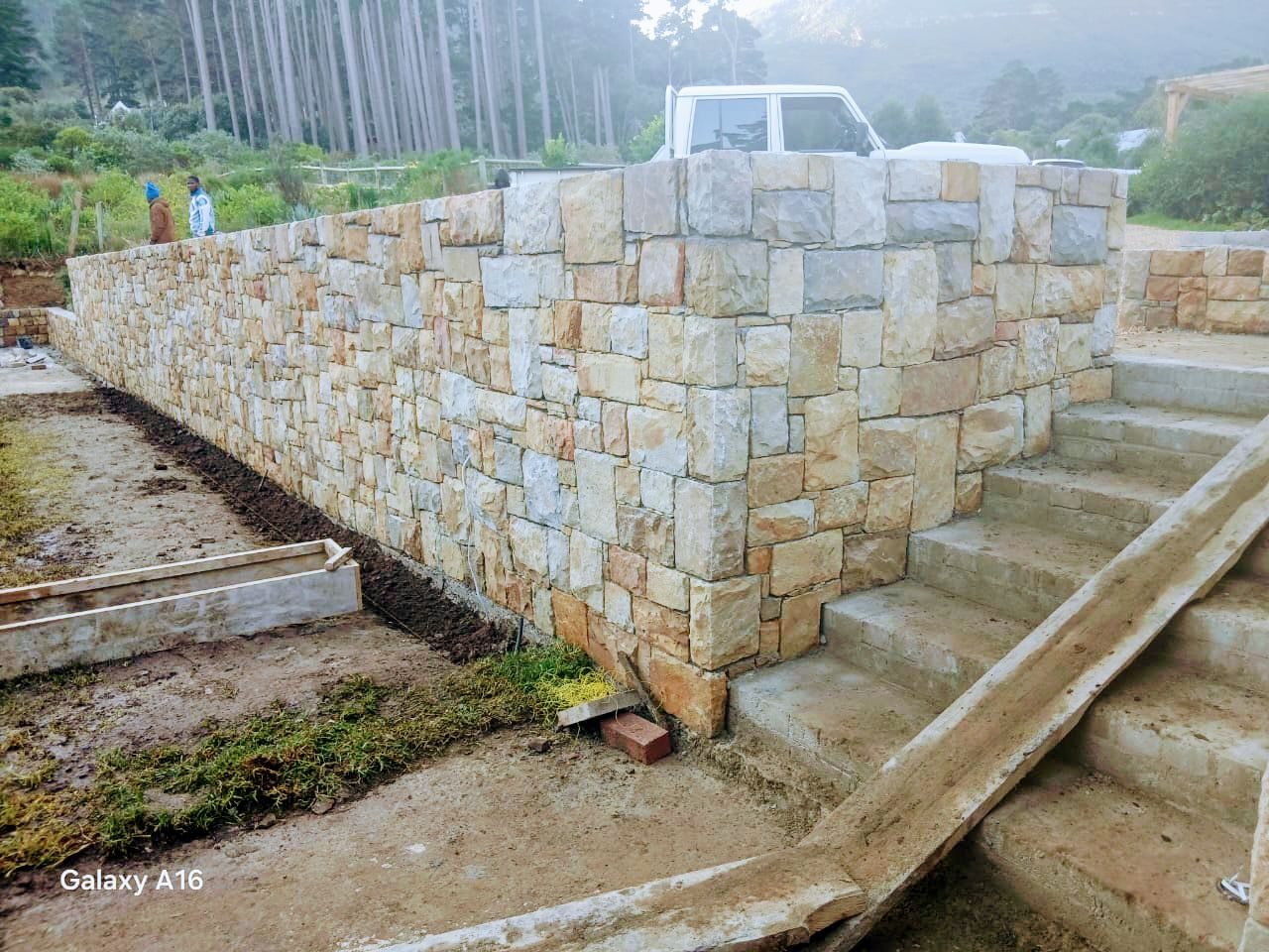 Natural stone retaining wall with cast steps on a sloped Cape Town property
